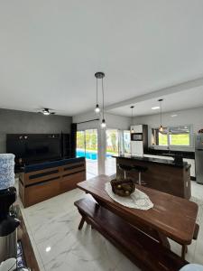 a large kitchen with a wooden table and a bench at refúgio urbano in Nova Odessa