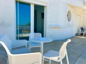 a patio with a table and chairs and a table at Sea Rooms - Torre Pali in Torre Pali