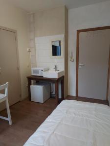 un bagno con lavandino e letto in una stanza di Deurne ad Anversa