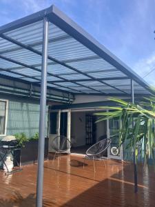 awning over a patio with two chairs and a table at Cozy, Modern, Quiet House in Westport