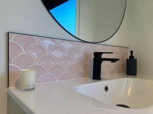a bathroom sink with a faucet and a mirror at Cozy, Modern, Quiet House in Westport +9 photos