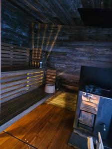 an empty sauna with a wood floor and a stove at The Lakeview Cabin in Kiruna