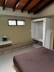 ein Schlafzimmer mit einem Bett und einem Fenster in der Unterkunft Residencia Las Lomitas in San Lorenzo de la Frontera