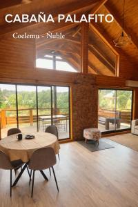 a living room with a table and chairs and windows at Cabaña Palafito in Coelemu +18 photos