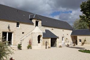 a large white brick building with a black roof at Les Pérelles in Saint-Vigor-le-Grand