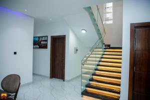 a staircase with a glass railing in a house at Luxury Double Bed Suite at THE HIDDEN DOMUS I Anomabo Suite in Accra