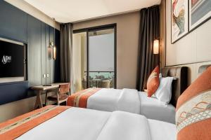 a hotel room with two beds and a window at April Hotel in Aqaba