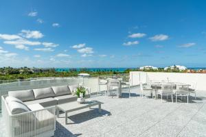 a patio with a couch and tables and the beach at Ellipse Resort, Grace Bay in Providenciales