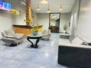a living room with a couch and chairs and a table at Hotel Summer Beach Paripueira Maceió in Paripueira