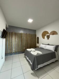 a bedroom with a large bed in a room at Pousada Flor De Prado in Prado