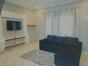 a living room with a couch and a flat screen tv at Happy Home in Weija