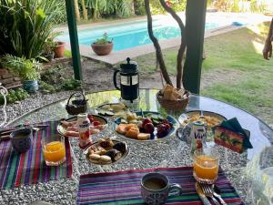 a glass table with breakfast foods and drinks on it at Montevideo Del Parque in Montevideo