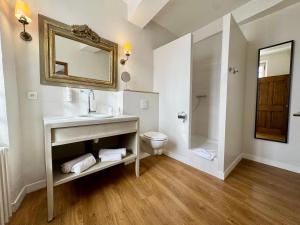 a bathroom with a sink and a toilet and a mirror at Hotel Du Midi in Visan