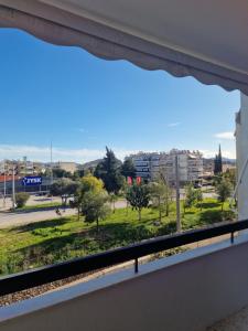 a window in a building with a view of a park at Dimitras Apartment with 3 bedrooms Elefsis in Eleusis