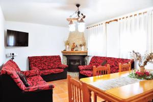 a living room with red furniture and a fireplace at Masia Campos Culla in Culla