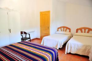 a room with two beds and a table and chairs at Masia Campos Culla in Culla