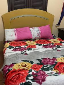 a bed with two pillows and a blanket on it at Casa Tradição do Catu in Aquiraz