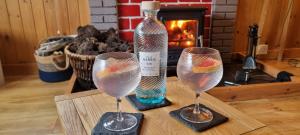 a bottle of wine and two wine glasses on a table at Pabbay House in Back +28 photos