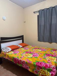 a bedroom with a bed with a colorful blanket at Casa Tradição do Catu in Aquiraz