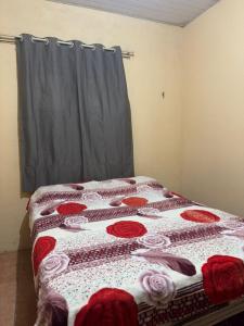 a bedroom with a bed with a red and white quilt at Casa Tradição do Catu in Aquiraz