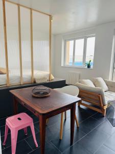a living room with a table and a couch at Brõcean - Studio with sea view - in Loctudy