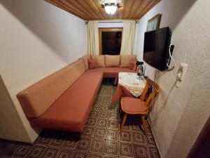 a room with a couch and a table and a tv at Gästehaus Gapp in Wildermieming