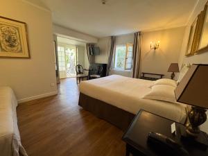 a hotel room with a large bed and a desk at Hotel Du Midi in Visan