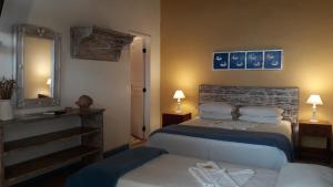 a hotel room with two beds and a mirror at Pousada Flor do Mar in Paraty