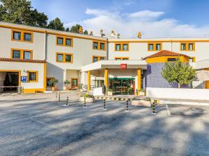 a large building with a parking lot in front of it at Hotel ibis Evora in Évora