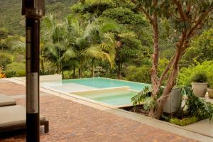 a swimming pool in the middle of a garden at Hotel Campestre Rancho La Lechería in Cali