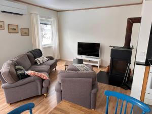 a living room with a couch and a tv at Ellös Holiday apartment in Ellös