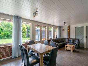 a living room with a table and chairs at Bungalow near Dutch Coast with Private Garden in Callantsoog