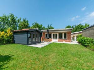 a house with a garden and a garage at Bungalow near Dutch Coast with Private Garden in Callantsoog
