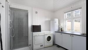 a white bathroom with a washing machine and a shower at Paradis ved Norefjell in Surteberg