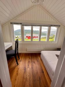 a bedroom with a bed and a desk and a window at Paradis ved Norefjell in Surteberg