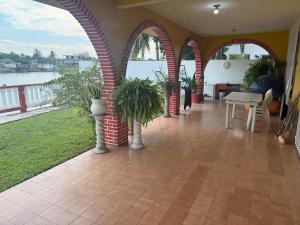 a patio with arches and a table and plants at Casa Pelícanos playa de chachalacas in Ursulo Galván