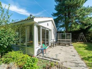 a small green greenhouse in a garden at Family Home by the Dunes in Sint Maartensvlotbrug
