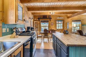 a kitchen with wooden walls and a dining room at BBQs, Hikes & Fireside Nights: Cabin in Black Hawk in Black Hawk