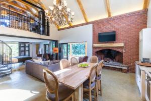 a dining room with a table and a fireplace at Devon Castle Forest Lodge in Stellenbosch