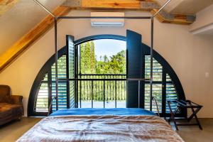 a room with a bed and a large window at Devon Castle Forest Lodge in Stellenbosch +71 photos