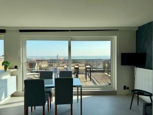 a living room with a table and chairs and a large window at Apartment Bel-Air in Knokke-Heist