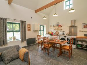 a kitchen and living room with a table and chairs at Bohan Bo in Kilmuckridge +10 photos