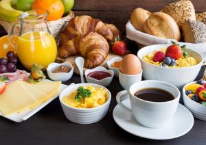 an assortment of breakfast foods and coffee on a table at Miðhraun - Lava resort & Restaurant in Midhraun