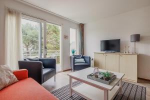 a living room with a couch and a table at Hollumerstrand in Hollum