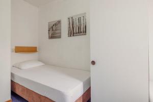 a bed in a room with two pictures on the wall at Hollumerstrand in Hollum +23 photos