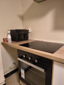 a kitchen with a stove and a microwave on a counter at Namur cozy apartment in Namur +4 photos