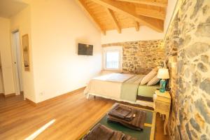 ein Schlafzimmer mit einem Bett und einer Steinwand in der Unterkunft Cà Bianca in Erba