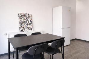a black table and chairs in a room with a refrigerator at Monteur- und Ferienunterkunft Waghäusel in Waghäusel