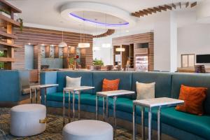a lobby with a blue couch and tables at EVEN Hotel Miami - Airport by IHG in Miami