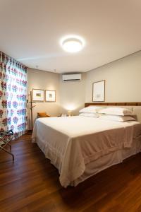 a bedroom with a large white bed and a window at Livramento Palace Hotel in Vitória da Conquista